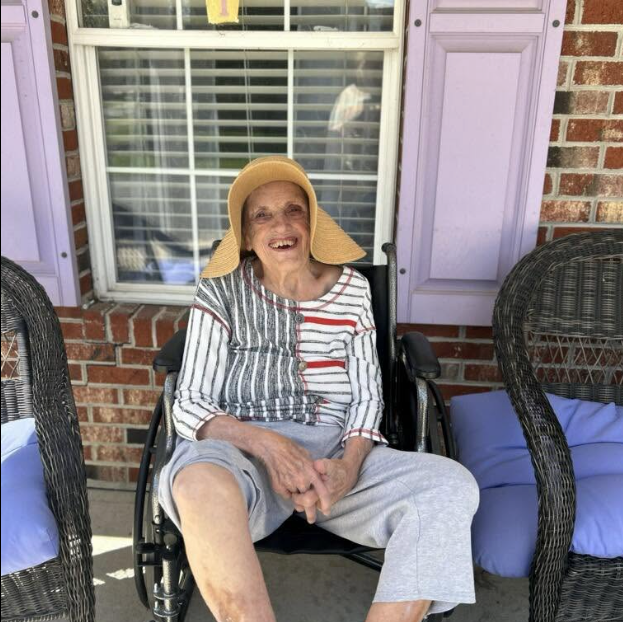 A resident in a sun hat laughing on the front porch of Lavender Fields on Water Street