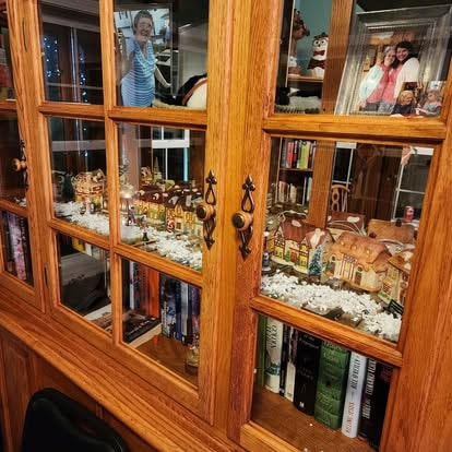 The china cabinet decorated with a miniature Christmas village at Lavender Fields