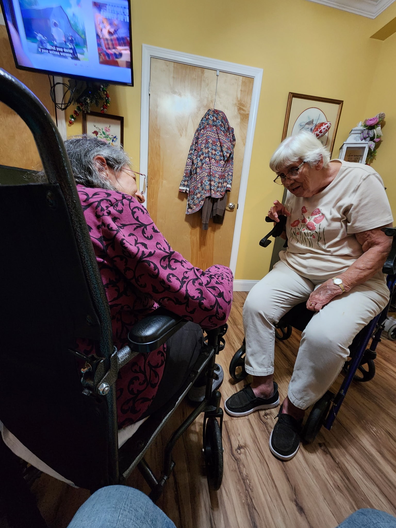 Two residents visiting together in one of their rooms at Lavender Fields