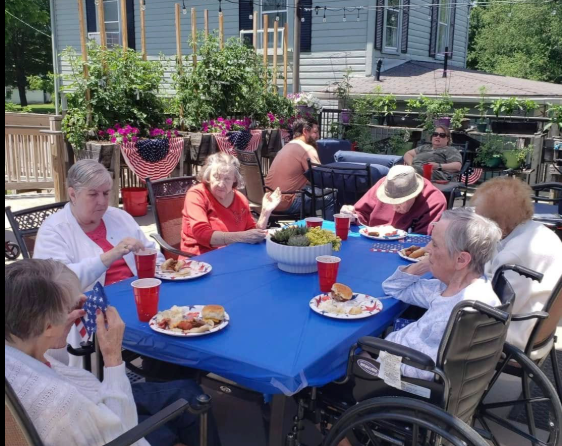 Residents dining together at an outdoor patio celebration at Lavender Fields
