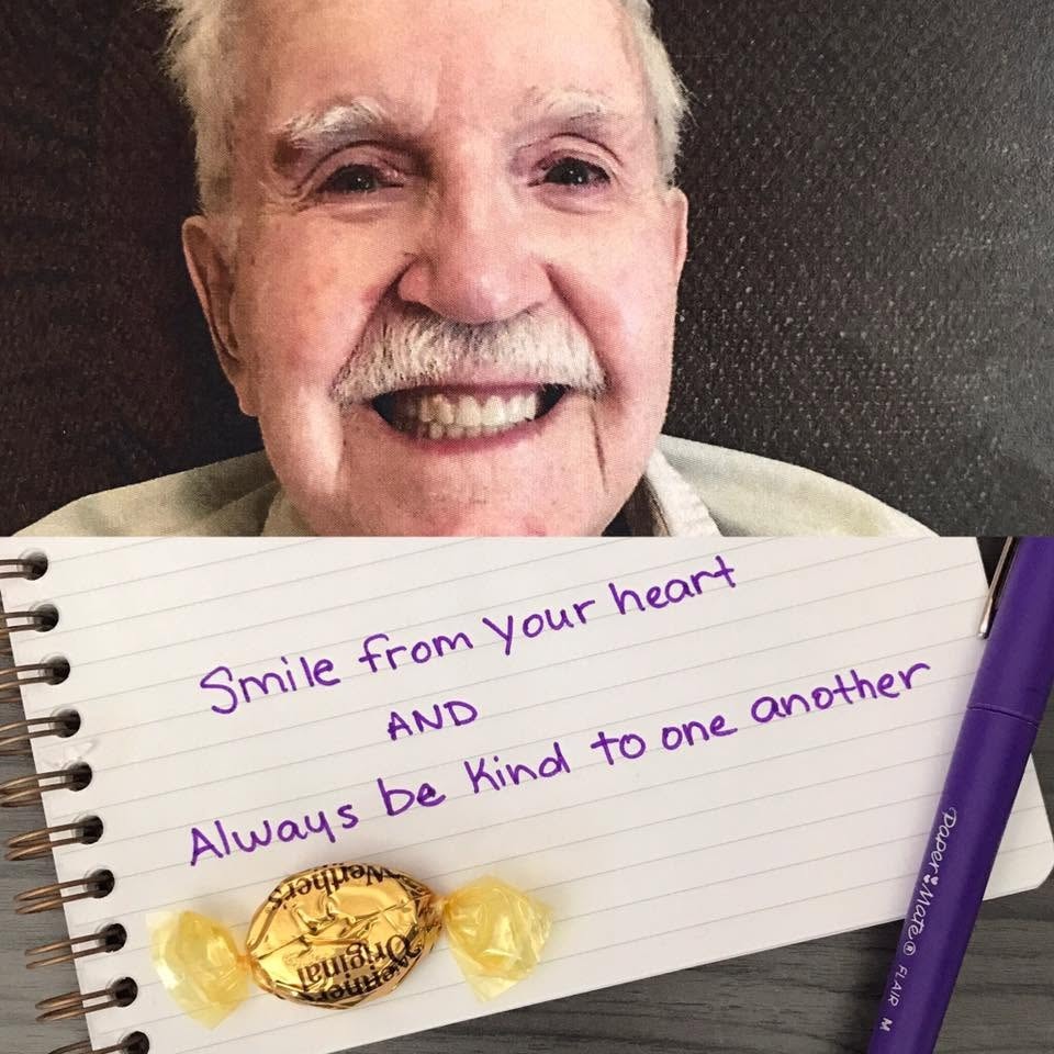 A resident smiling warmly above a notepad that reads: Smile from your heart AND Always be kind to one another