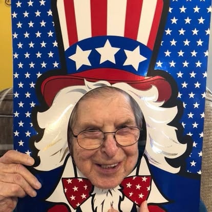 A resident posing through a patriotic Uncle Sam photo cutout at a Fourth of July celebration at Lavender Fields